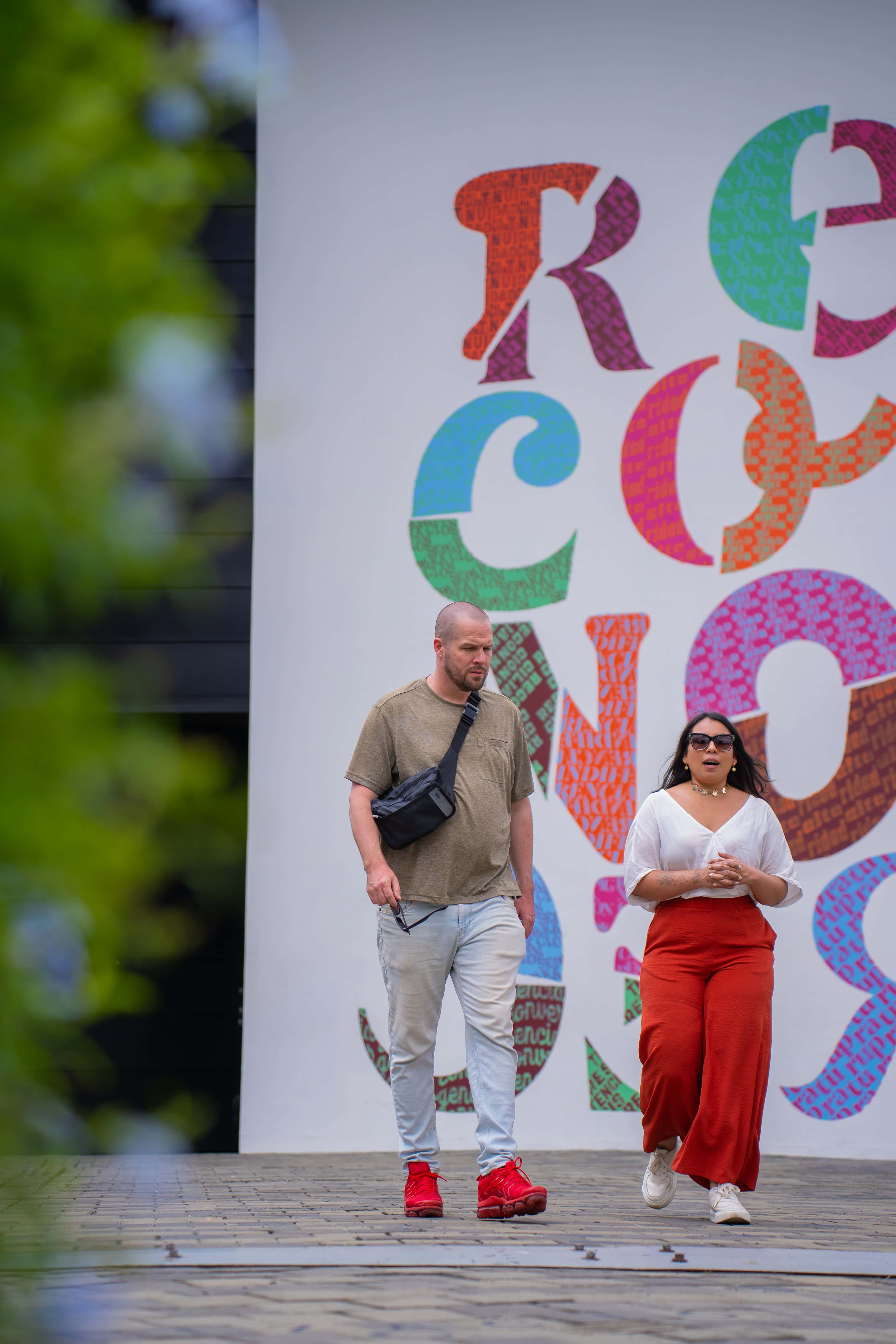 Couple in front of the Reconocernos mural in Medellín